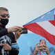Bad Bunny waves a flag during a 2019 national strike demanding Puerto Rico’s Governor Ricardo Rossello resignation.